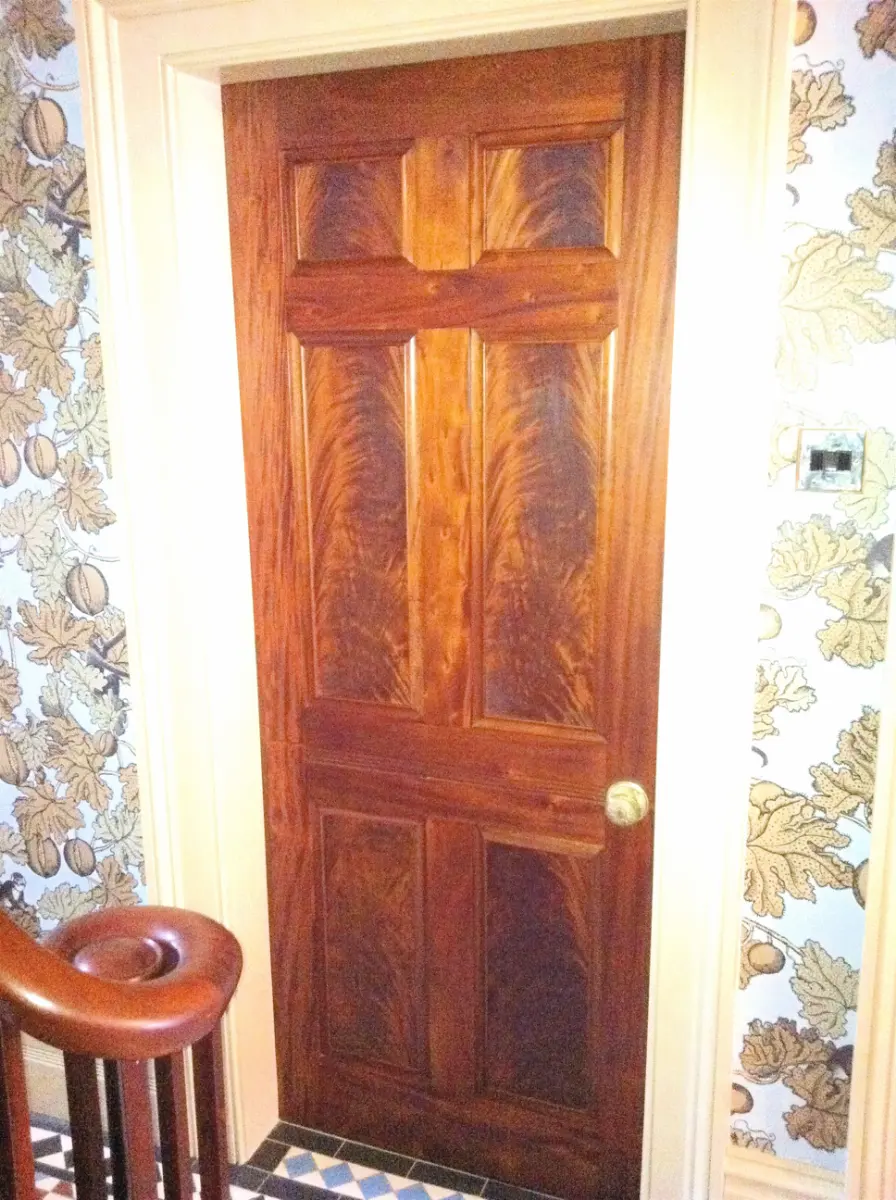 Georgian-style panelled internal door in richly figured hardwood with a brass knob