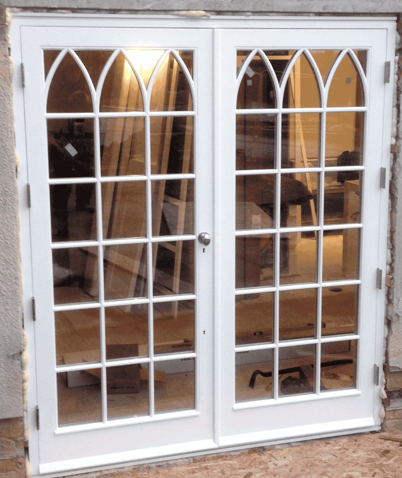 Elegant grey front door with ornate stained glass panels and matching sidelights and transom, featuring colourful geometric and floral designs, framed by an arched porch.